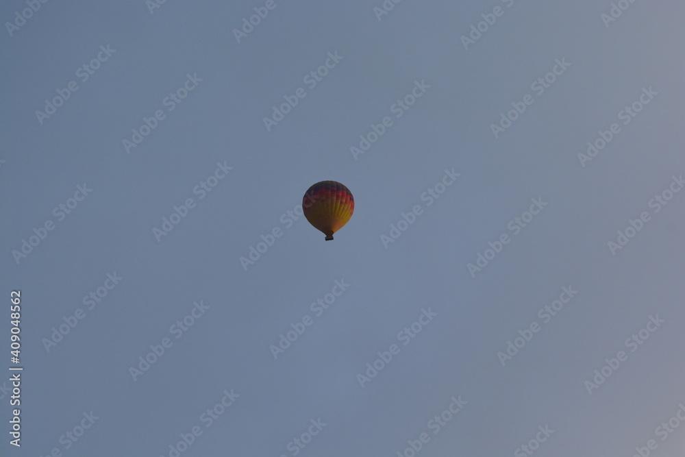 Tourist hot air balloons floating in the cloudy sky in Cappadocia. Cloudy weather. Colorful balloons. Tourist hot air balloons floating in the cloudy sky in Cappadocia. Cloudy weather. Colorful balloons.