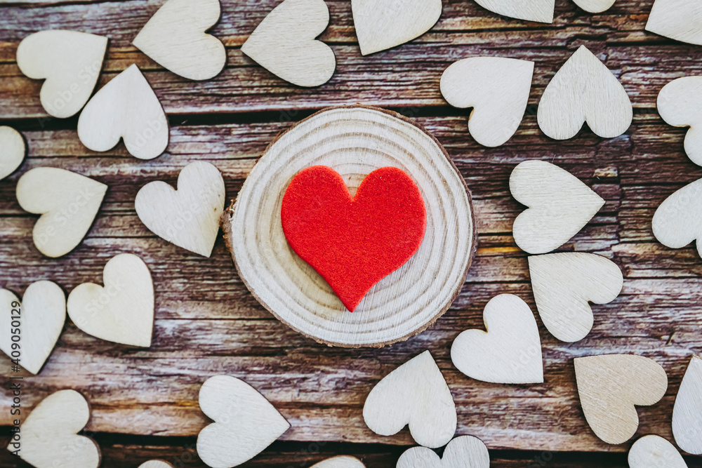 Coeur rouge et plusieurs coeurs en bois sur un fond en bois vintage