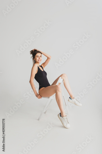 Cool. Beautiful young woman's isolated on white studio background. Having fun, happy, full length. Dancing, getting crazy mood, stylish posing. Fit girl in black sportive swimsuit. Copyspace.