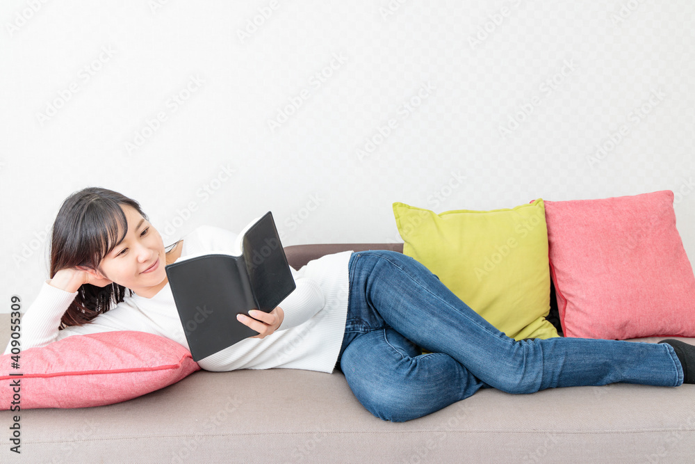 Woman lying on the sofa reading a book Woman lying on the sofa reading a book