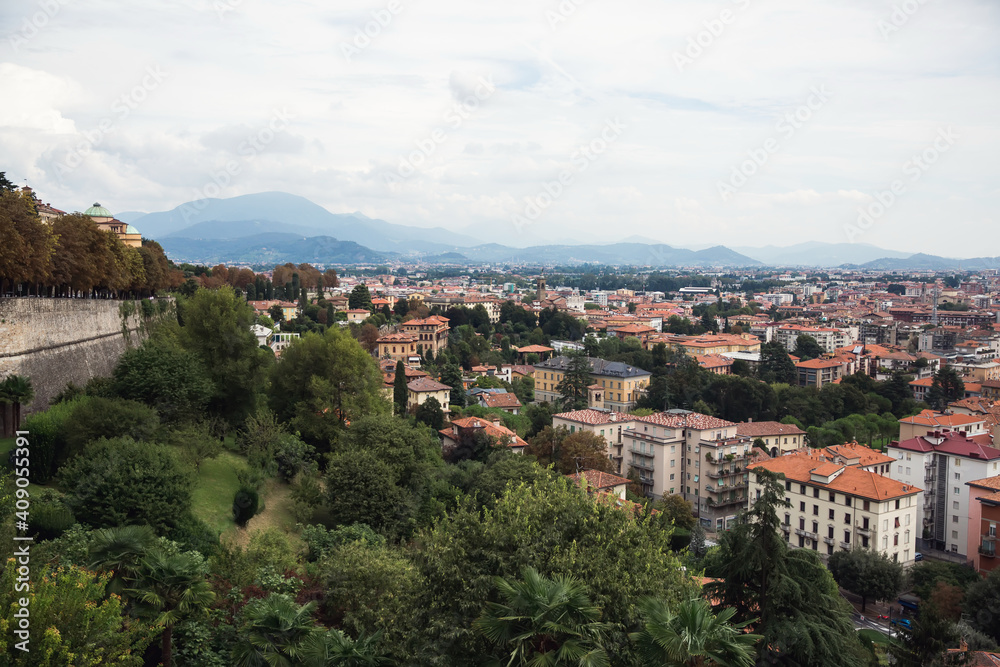 Top view of houses, streets of old Italian city of Bergamo and mountains. Panorama of city.