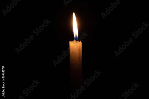 Una vela sobre un fondo completamente oscuro