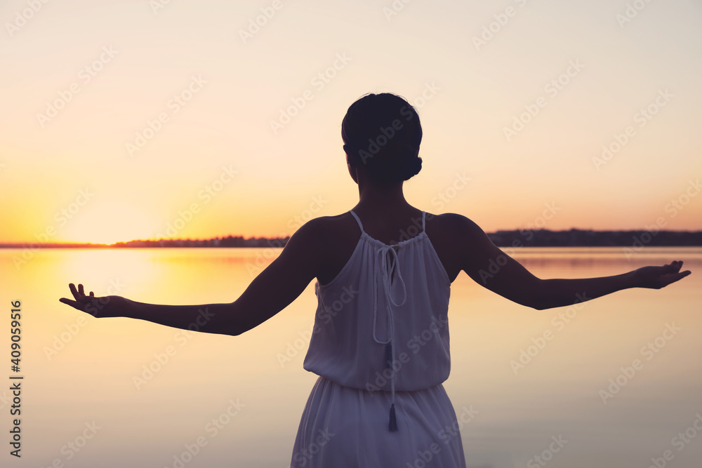 Woman near river on sunset. Healing concept