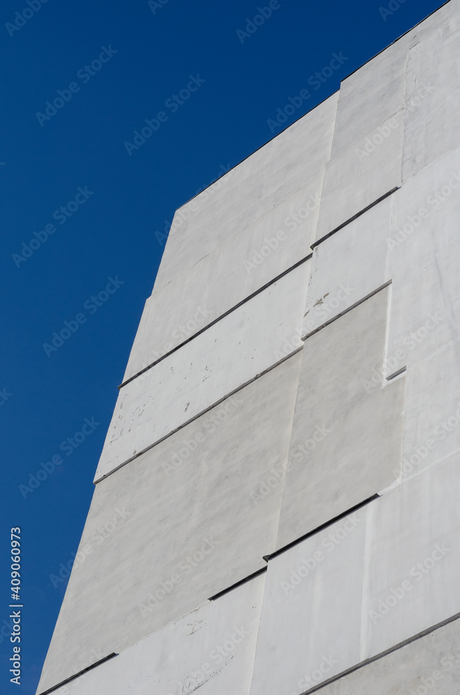 A fragment of a tall residential building against a clear blue sky. A fragment of a tall residential building against a clear blue sky.