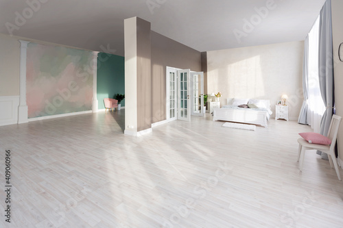 Luxurious and expensive interior of an open-plan apartment in light colors. Stylish modern bedroom with minimal design  dining area and guest space.