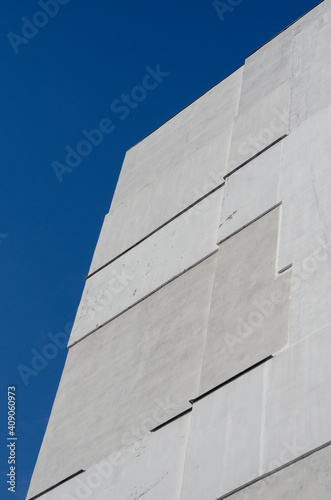 A fragment of a tall residential building against a clear blue sky.