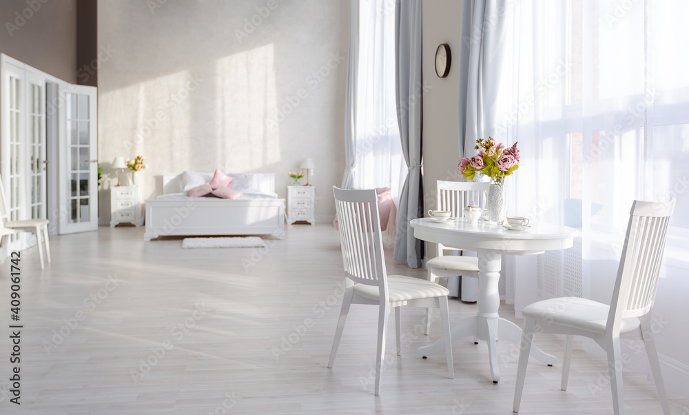 Luxurious and expensive interior of an open-plan apartment in light colors. Stylish modern bedroom with minimal design, dining area and guest space. Luxurious and expensive interior of an open-plan apartment in light colors. Stylish modern bedroom with minimal design, dining area and guest space.