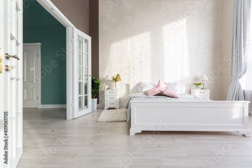 Stylish modern bedroom with a minimalistic design in a luxurious rich, expensive interior of an open-plan apartment in light colors.