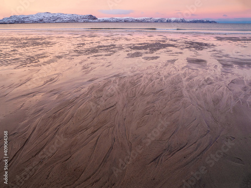 The texture of the sand on the sea beach at low tide at sunset.