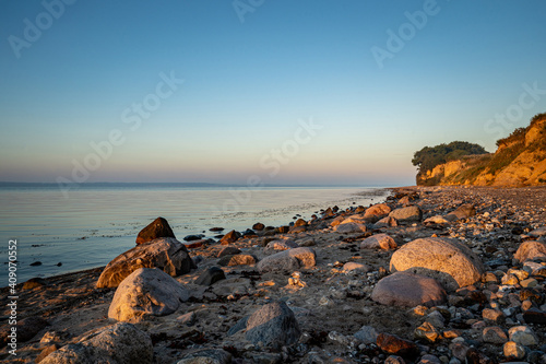 Steiniger Strand vor der Steilküste bei Klein-Waabs bei Eckernförde in Schleswig-Holstein im Morgenlicht. photo