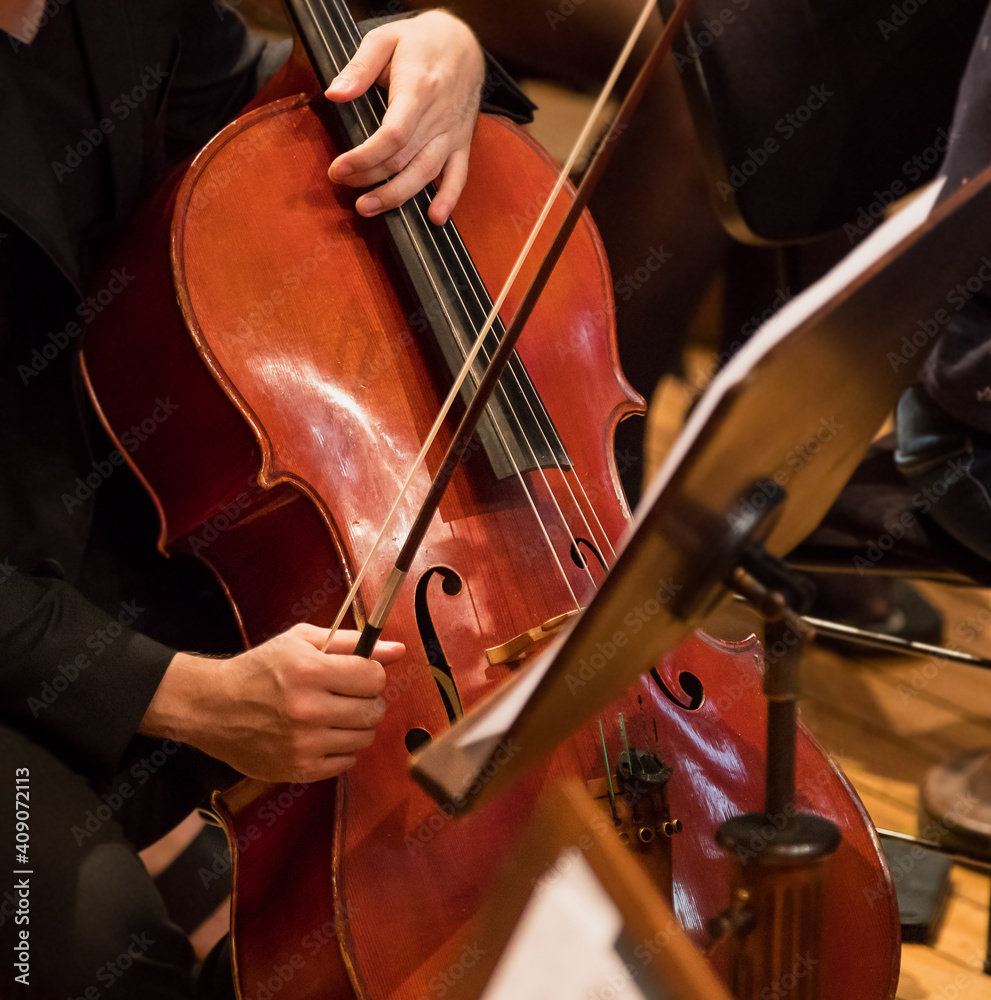 Contrabass professional player with symphony orchestra performing in concert on background. Contrabass professional player with symphony orchestra performing in concert on background.