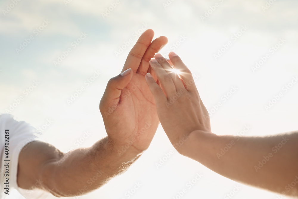 Man and woman reaching hands to each other at sunset, closeup. Nature healing power Man and woman reaching hands to each other at sunset, closeup. Nature healing power