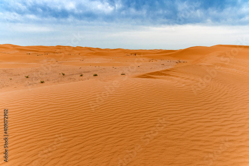 Picturesque desert landscape with dunes and dramatic sky