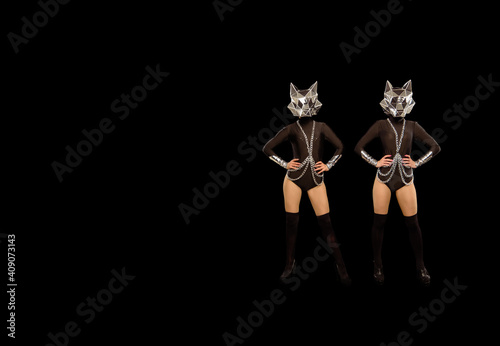Two go-go variety show dancers in wolf masks on black