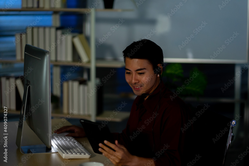 Asian business employee working in call center customer service office in the night 