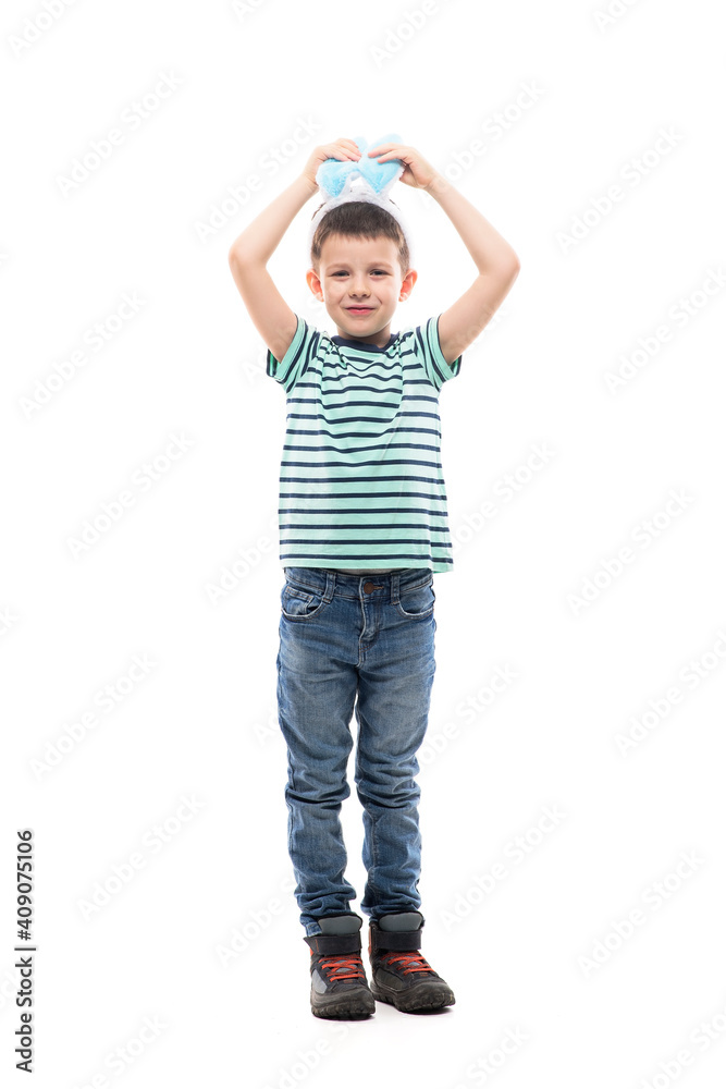 Cute young boy wearing Easter bunny ears touching ears smiling insecure at camera. Full length isolated on white background. Cute young boy wearing Easter bunny ears touching ears smiling insecure at camera. Full length isolated on white background.