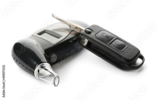 Modern breathalyzer and car key on white background
