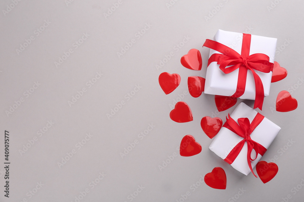 Beautiful gift boxes and hearts on grey background, flat lay with space for text. Valentine's day celebration Beautiful gift boxes and hearts on grey background, flat lay with space for text. Valentine's day celebration