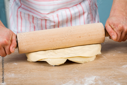 cooking concept - Happy male chef holding a rolling pin for dough.