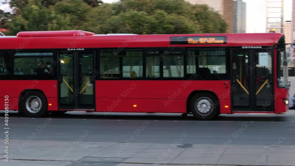 Red bus driving going around the Republic Square