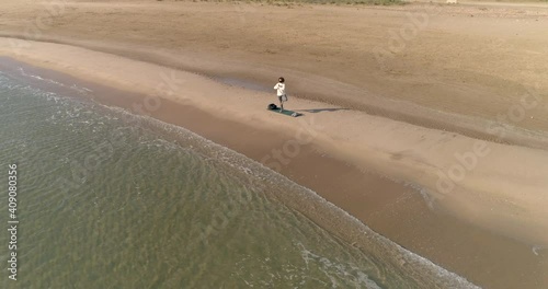 bella mujer con mascarilla covid-19 realizando posturas de yoga en la playa y vuelo dron orbital photo