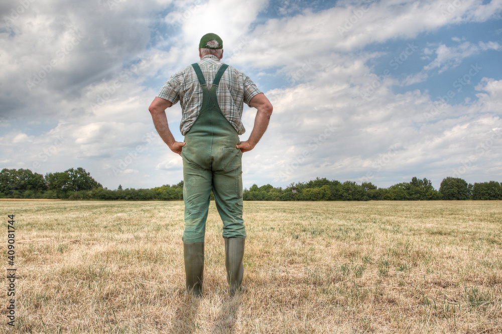 A farmer stands on his parched meadow and hopes for rain while the sun shines mercilessly on his farmland. Rising temperatures and too little rain the arable land in Germany is dry like never before. A farmer stands on his parched meadow and hopes for rain while the sun shines mercilessly on his farmland. Rising temperatures and too little rain the arable land in Germany is dry like never before.