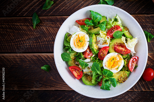 Fresh avocado salad with tomato, avocado, boiled eggs and fresh lettuce. Ketogenic diet breakfast.  Keto, paleo salad. Top view, overhead, above photo