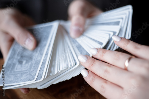 Man holds a deck of tarot cards in his hands and woman draws a card