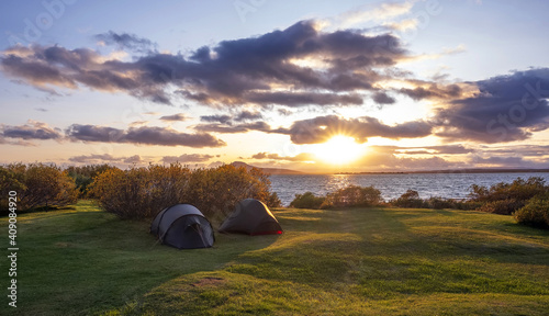 Two tents in a camping on the shore of Lake Myvatn, evening horizontal panorama