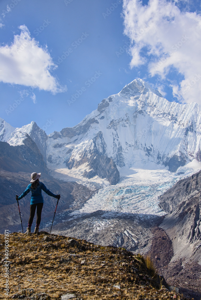A trekker with an incredible view of Yerupajá from above Siula Grande Base Camp on the Cordillera Huayhuash circuit, Ancash, Peru