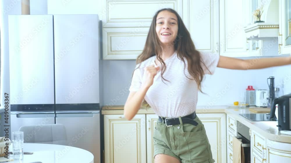 beautiful girl dancer cheerfully dancing at home in the kitchen. beautiful girl dancer cheerfully dancing at home in the kitchen.
