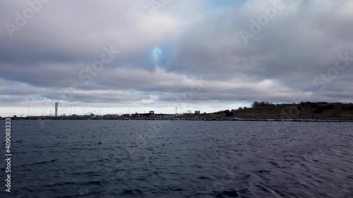 Panning shot over the oresund, öresund, body of water in Malmö, Sweden. The turning torso in the horizon on a beautiful cloudy day. 4K photo