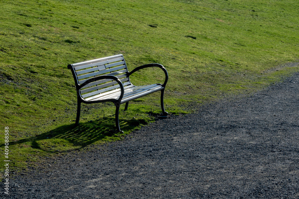 Black metal park bench beside path Black metal park bench beside path