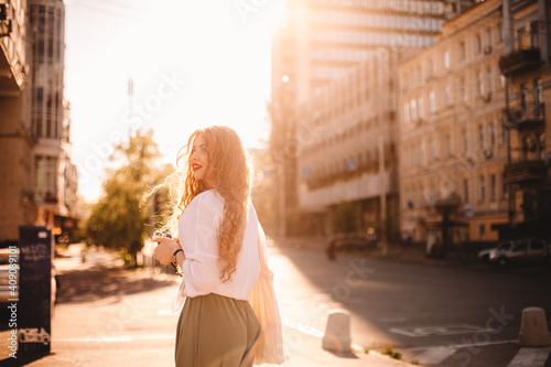 Happy young woman standing on street in city during summer