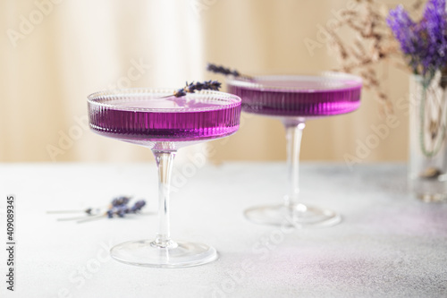 Sticker Purple cocktail drink in a glass on white background with flowers
