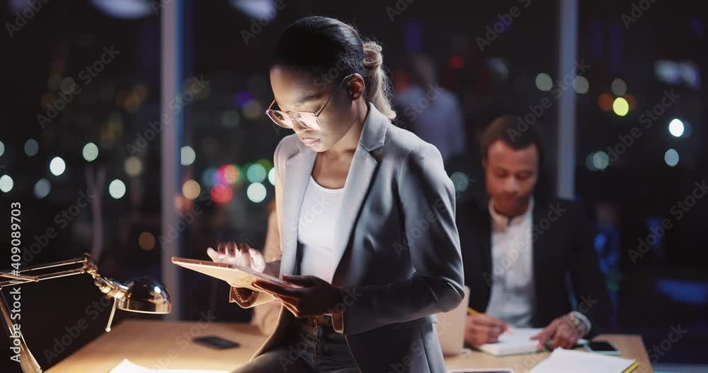 African american female real estate agent using digital tablet working long hours in the company office building. Corporate people. Tablet computer technology.