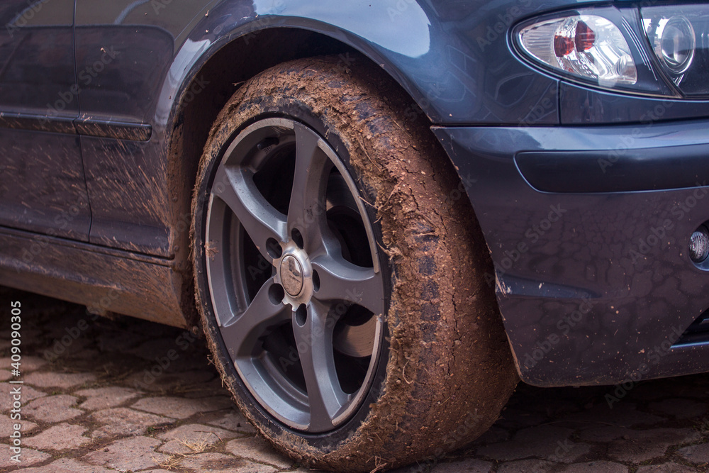 Wheel close up in countryside landscape with muddy road