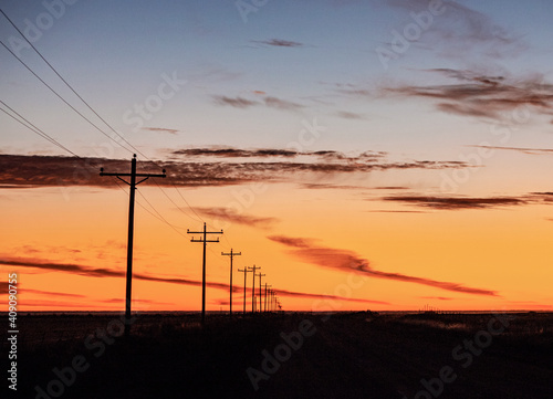 Powerline receding into distance at sunrise in the American midwest
