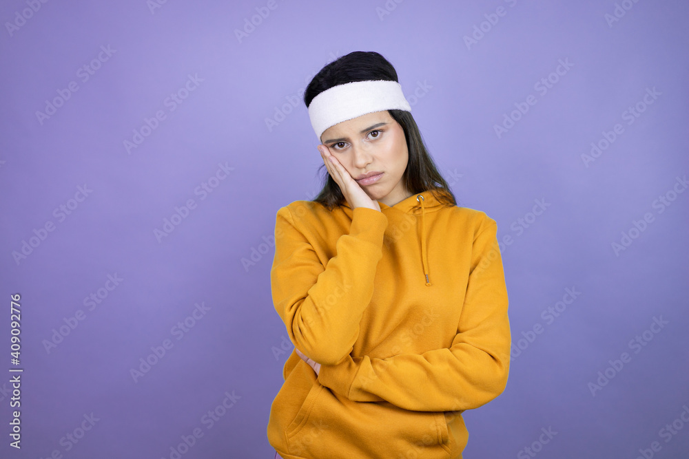 Young latin woman wearing sportswear over purple background thinking looking tired and bored with crossed arms