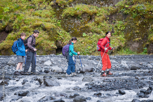 mother leading her children through canyon in Iceland photo