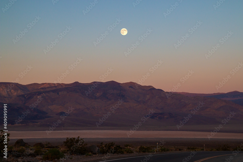 California desert with full moon before sunrise, Road trip through typical southwest American desert, Death Valley, USA