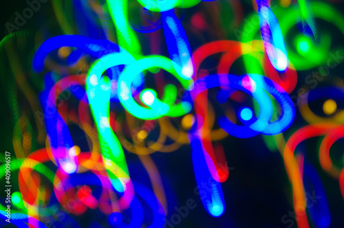 Bokeh blue background. Bright festive multicolored circles and lines in motion. Defocused abstract colorful lights 