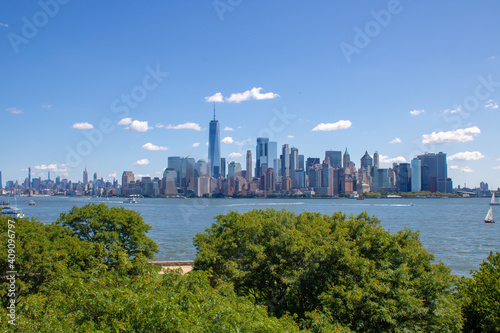 Skyline of lower Manhattan with green bushes. View at New York at a summer day