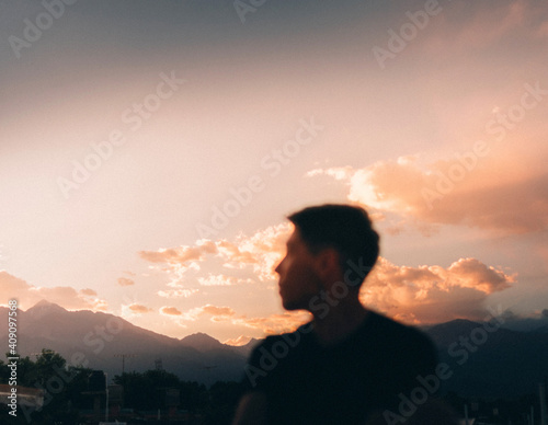 man admiring the sunset with his face blurred photo