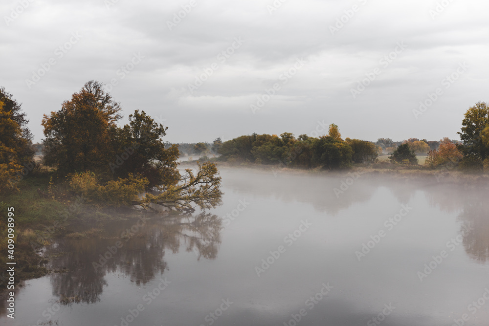 foggy autumn landscape with river and trees 