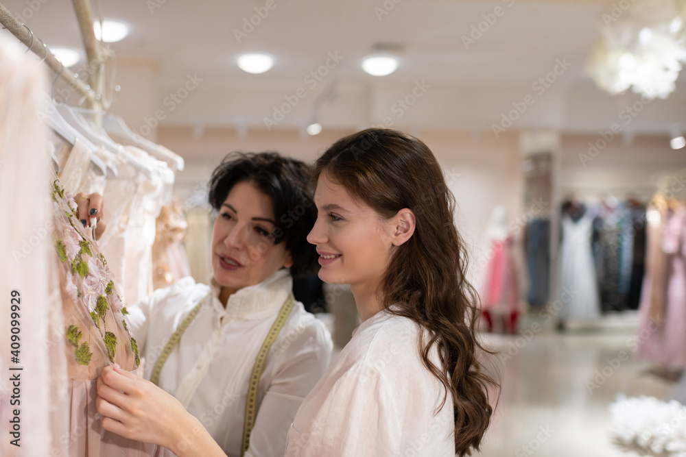 Female customer choosing outfit with help of shop assistant Female customer choosing outfit with help of shop assistant