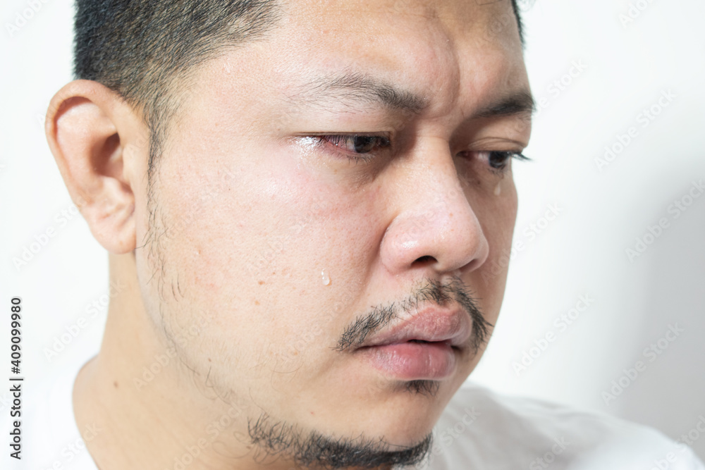 Obraz premium Portrait of unhappy and depressed man with black hair, feeling ashamed or sick, keeping eyes closed. Human face expressions and emotions concept. Isolated studio shot on gray background.