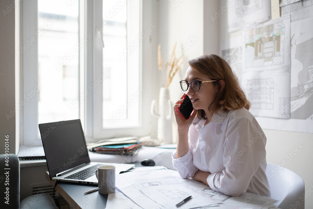 Friendly female architect making call to client Friendly female architect making call to client