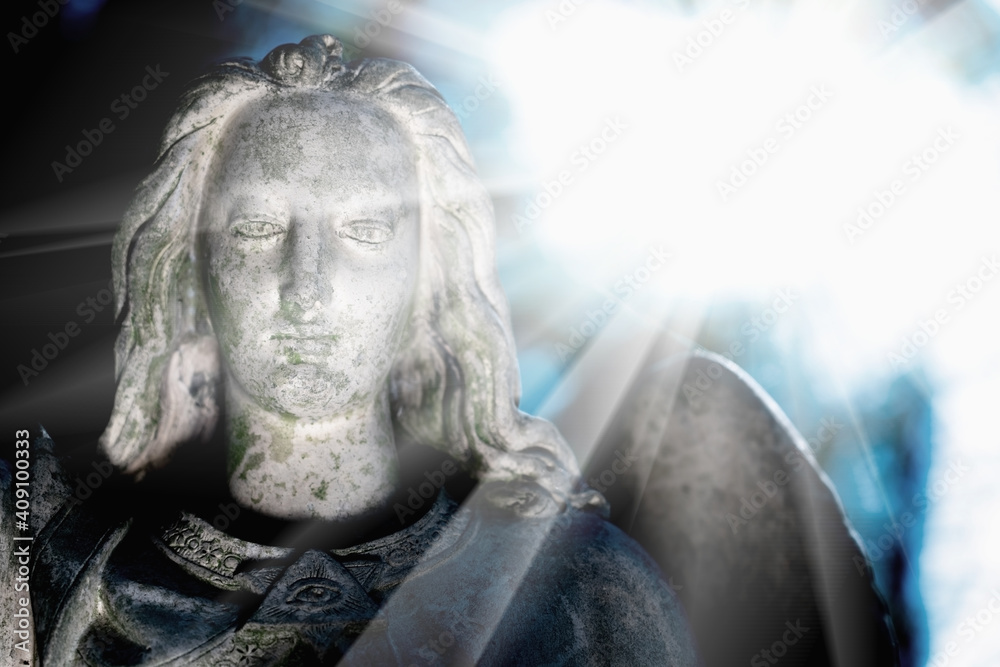 Obraz premium Beautiful guardian angel in sun rays. Bery ancient stone statue.
