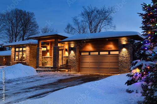 Snow covered modern house in Ontario Canada with Christmas lights in winter